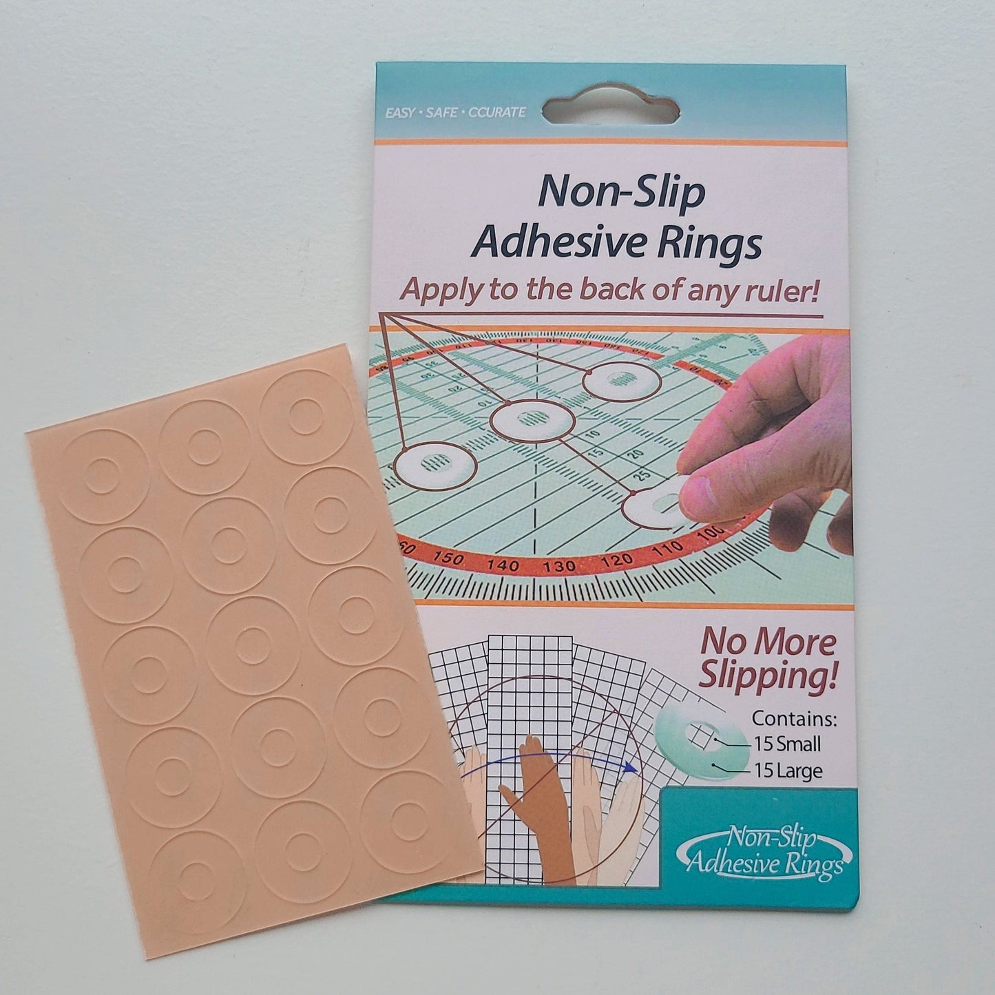 Package of non-slip adhesive rings next to a sheet of rings.