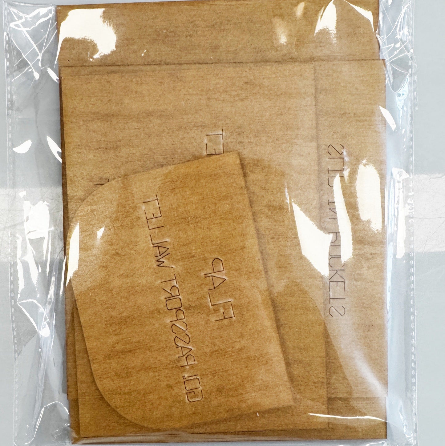 Brown paper template pieces in clear plastic,...