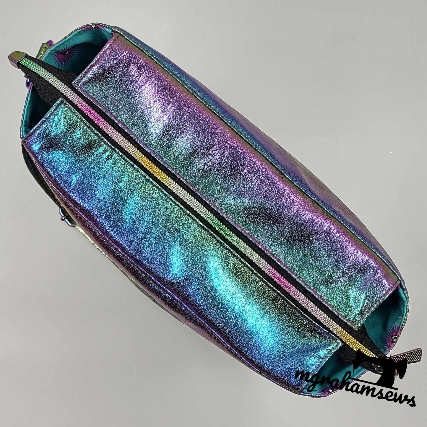 Iridescent blue and purple handbag with zipper.