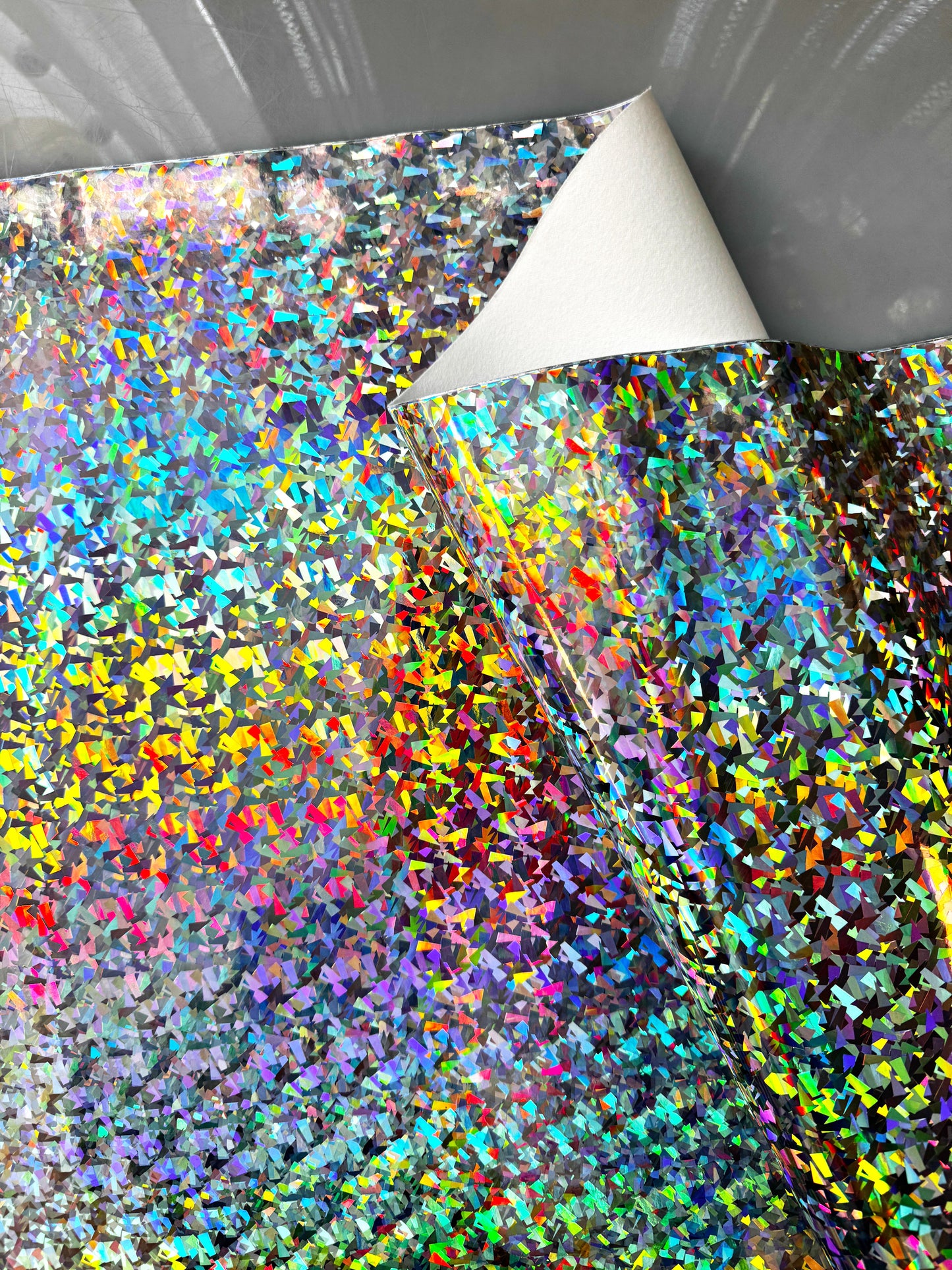 Holographic sheet with colorful confetti pattern,...