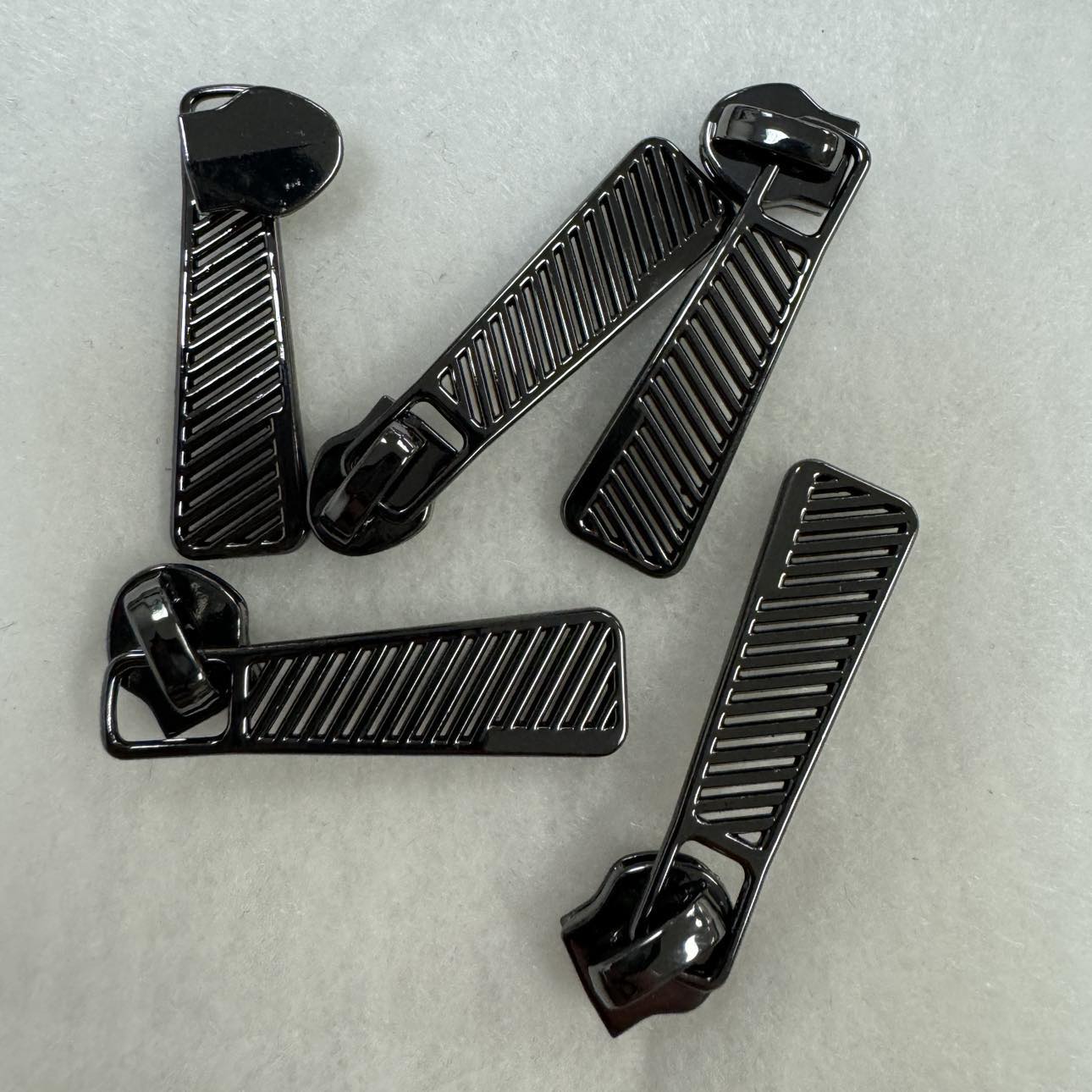 Black zipper pulls on white background.