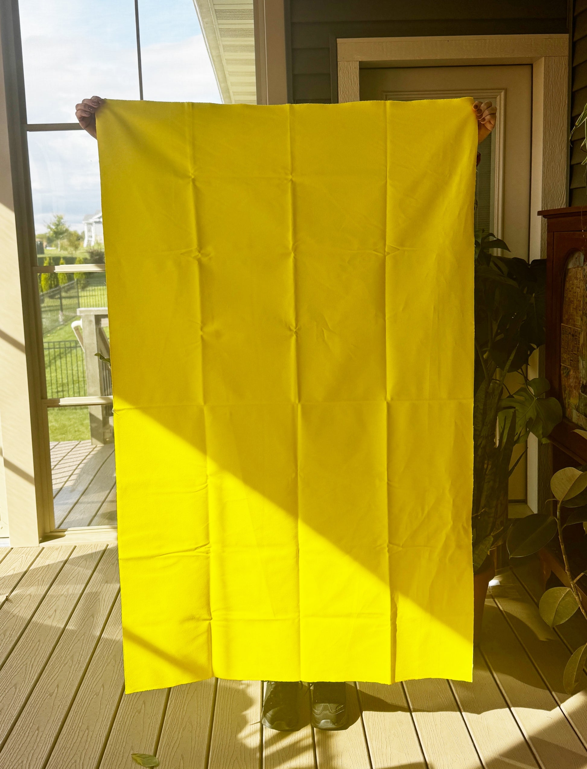Bright yellow fabric held up (9D71811B-56C3)