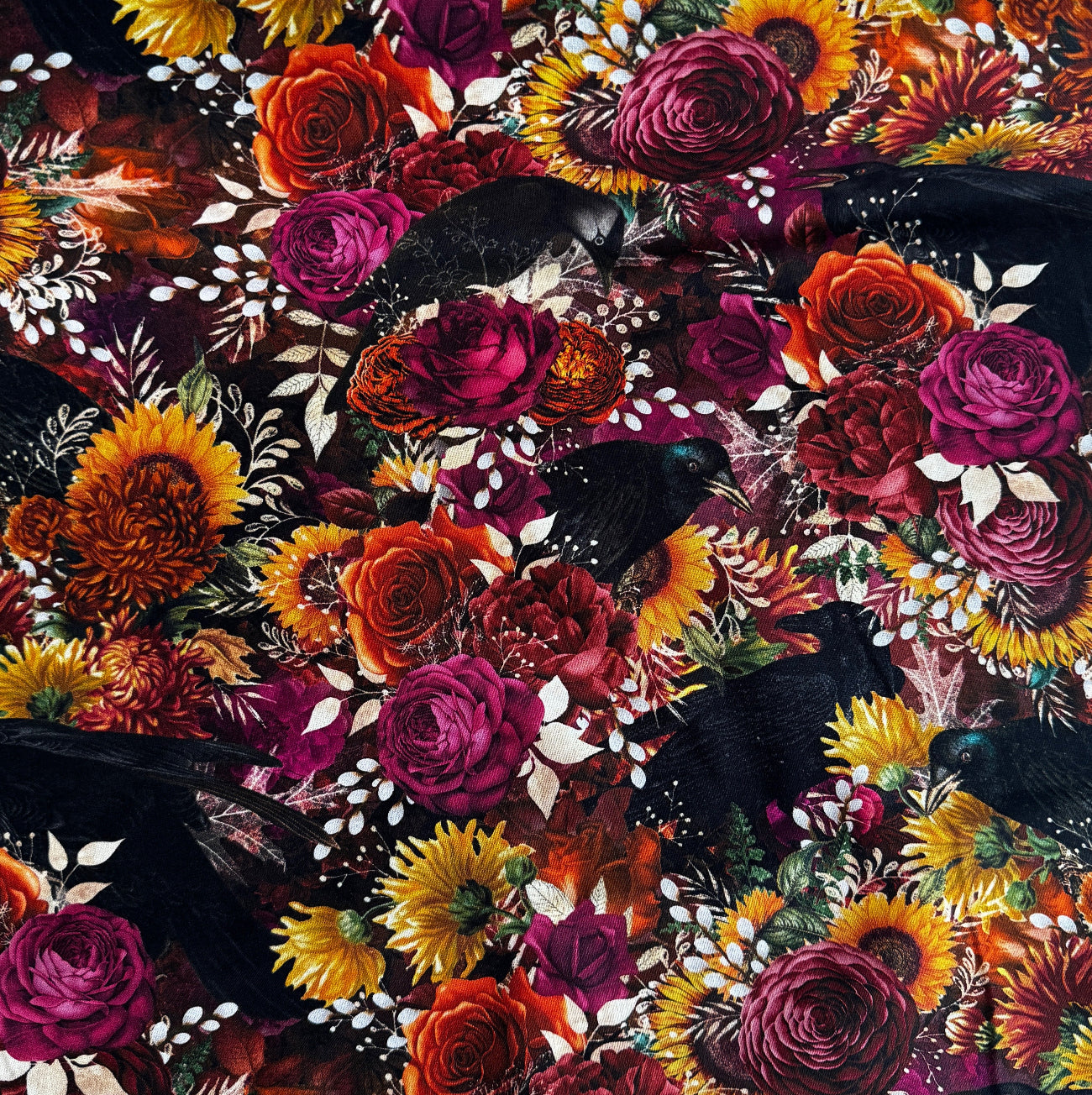 Gothic autumn floral fabric featuring black crows, sunflowers, and rich magenta roses by Robert Kaufman.