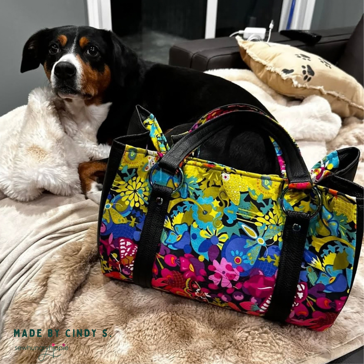 Duffle-style bag in Alison Glass Art Theory Night print with black handles, beside a dog on a blanket
