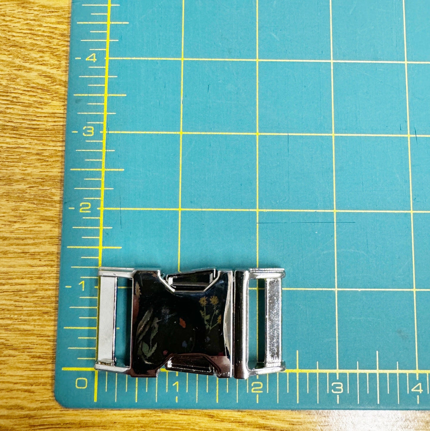 Shiny metal buckle on cutting mat.