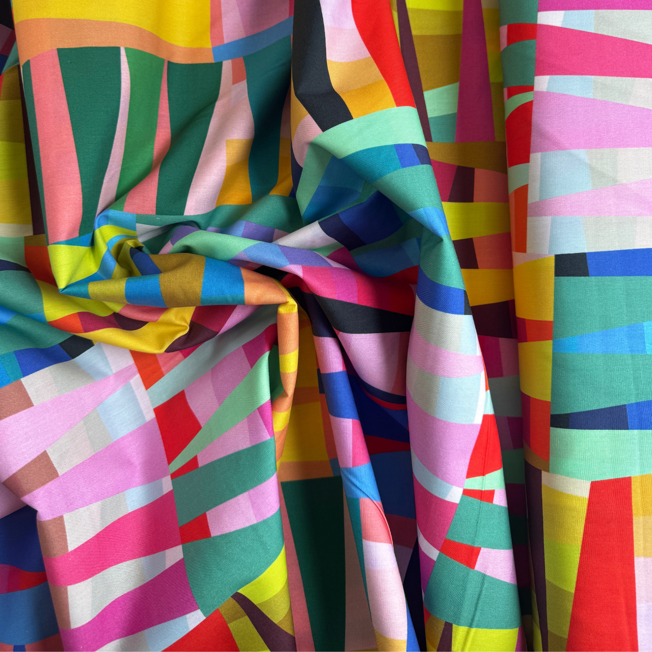 Colorful fabric with geometric patterns in various bright colors.