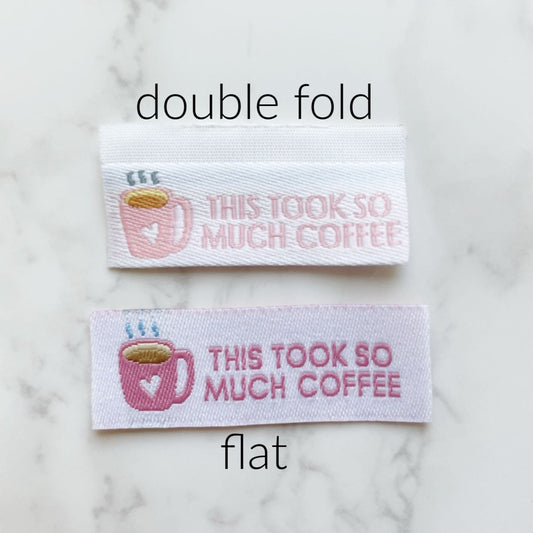 Two white fabric labels with coffee mug design and text.