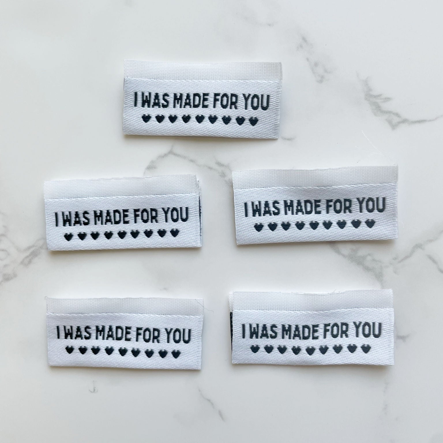 Five white labels with I WAS MADE FOR YOU text and heart symbols.