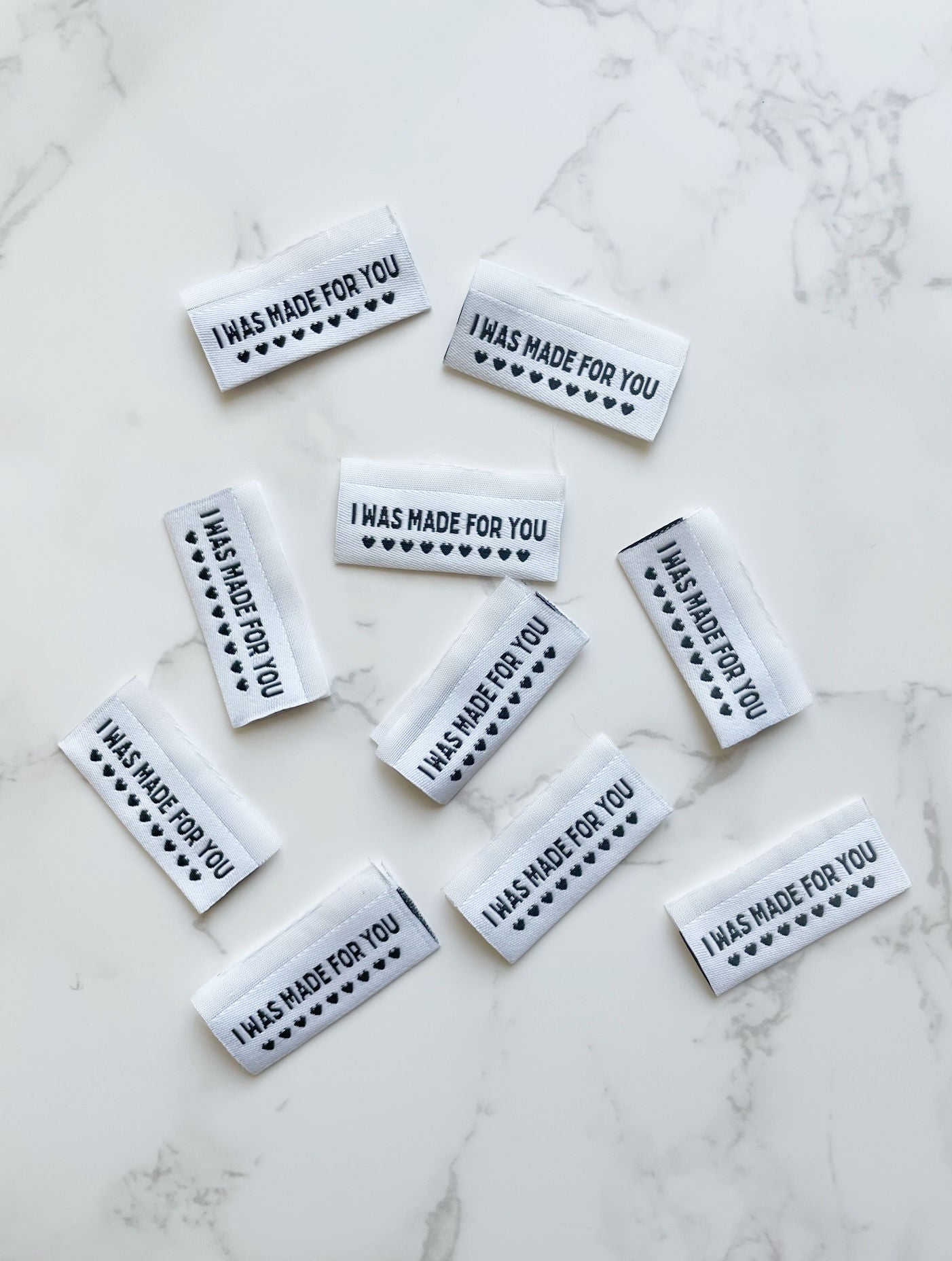 White fabric labels with I WAS MADE FOR YOU text and hearts.