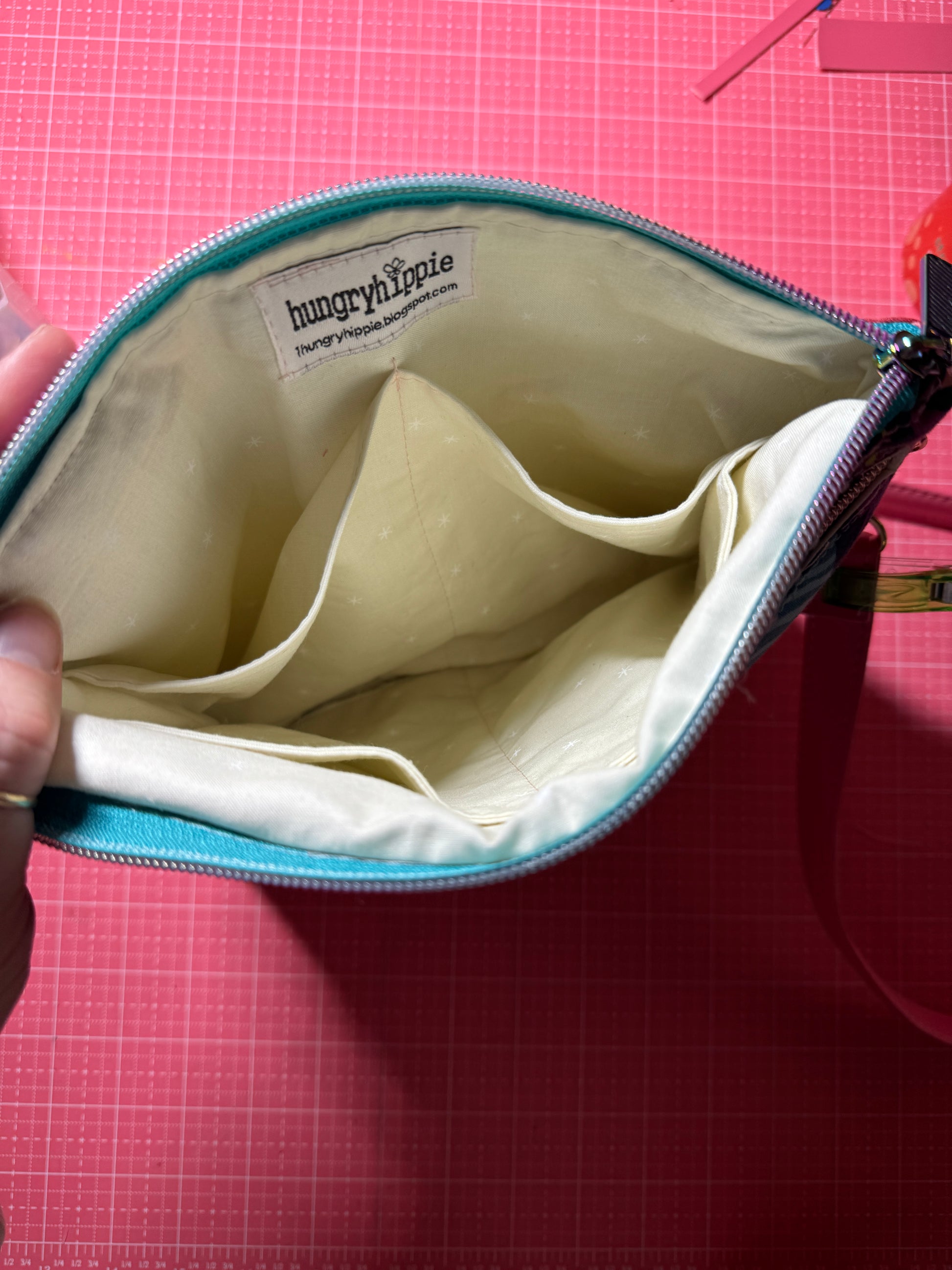 Open teal purse with pockets.