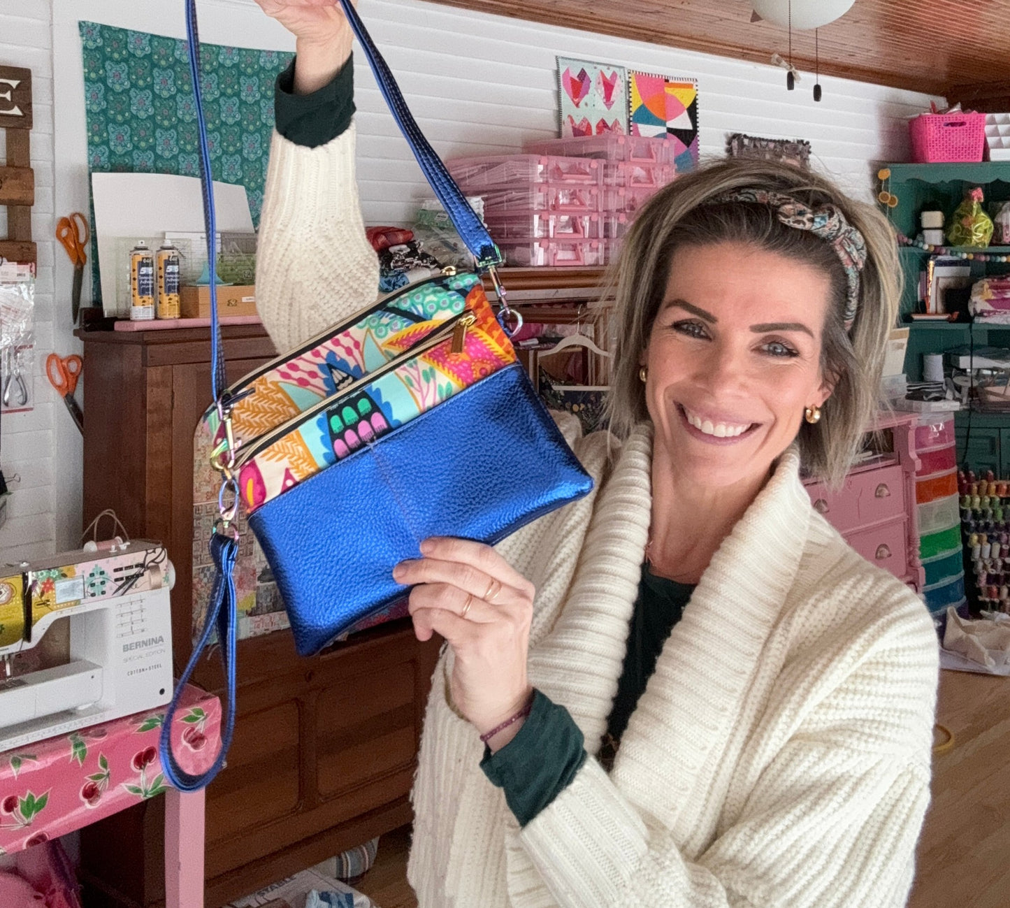 Woman holding a blue and patterned handbag.