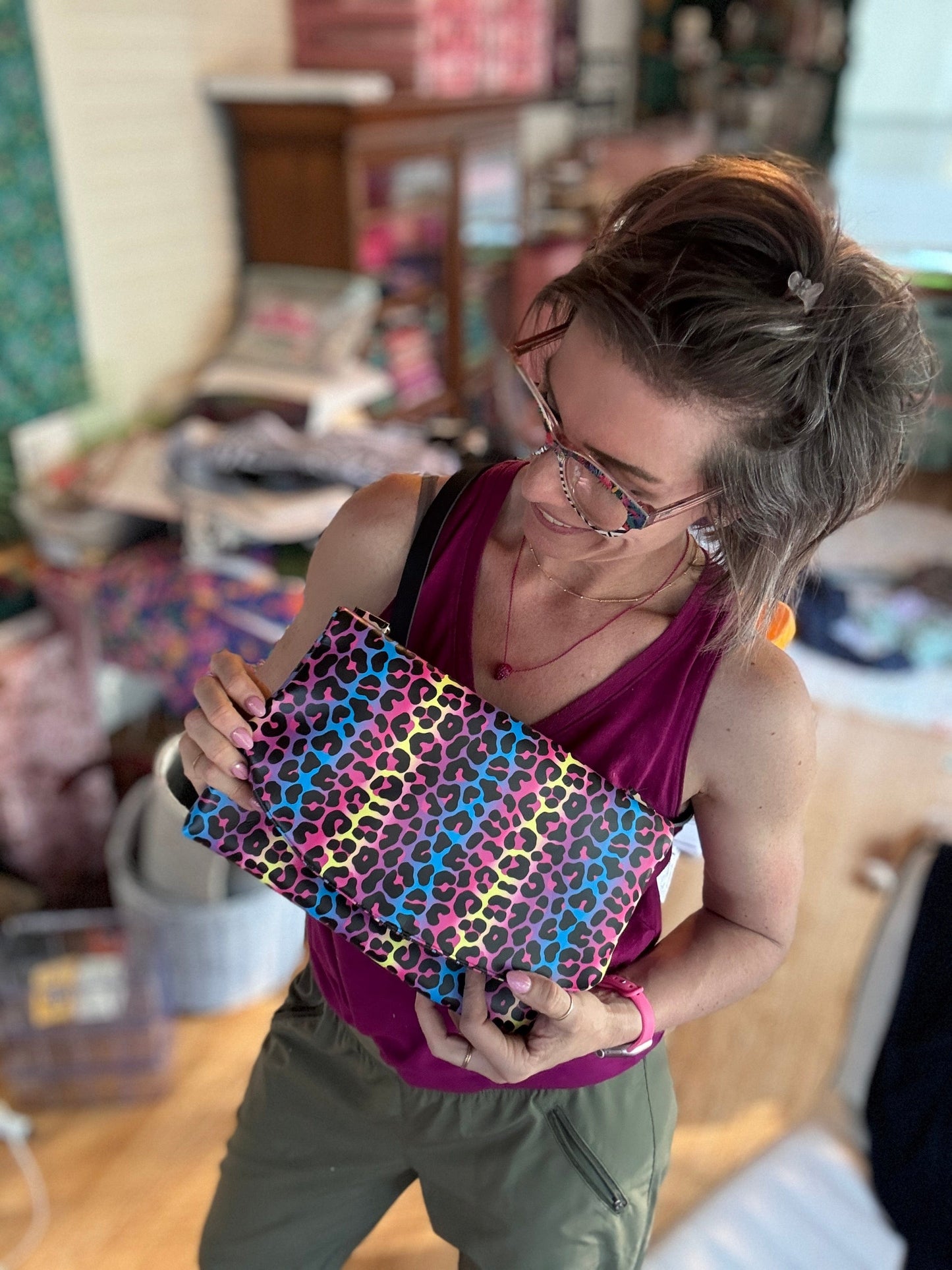 Woman holding a colorful leopard print clutch.