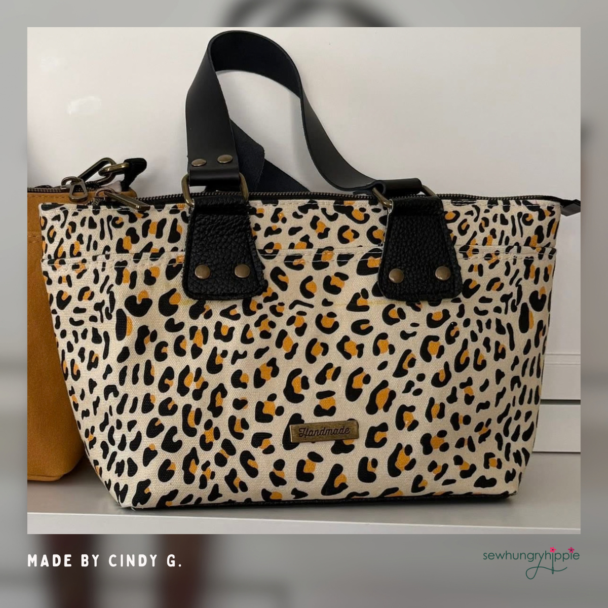 Leopard print canvas tote with black handles and tabs