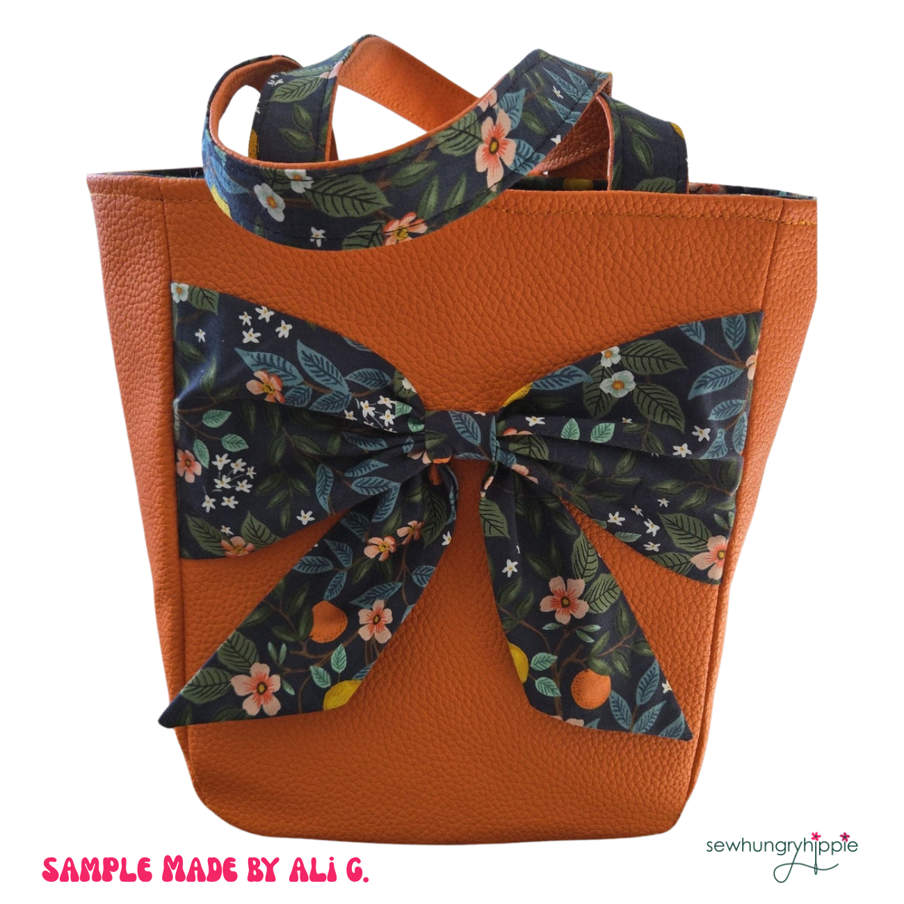 Orange tote bag with floral bow and strap on a white background
