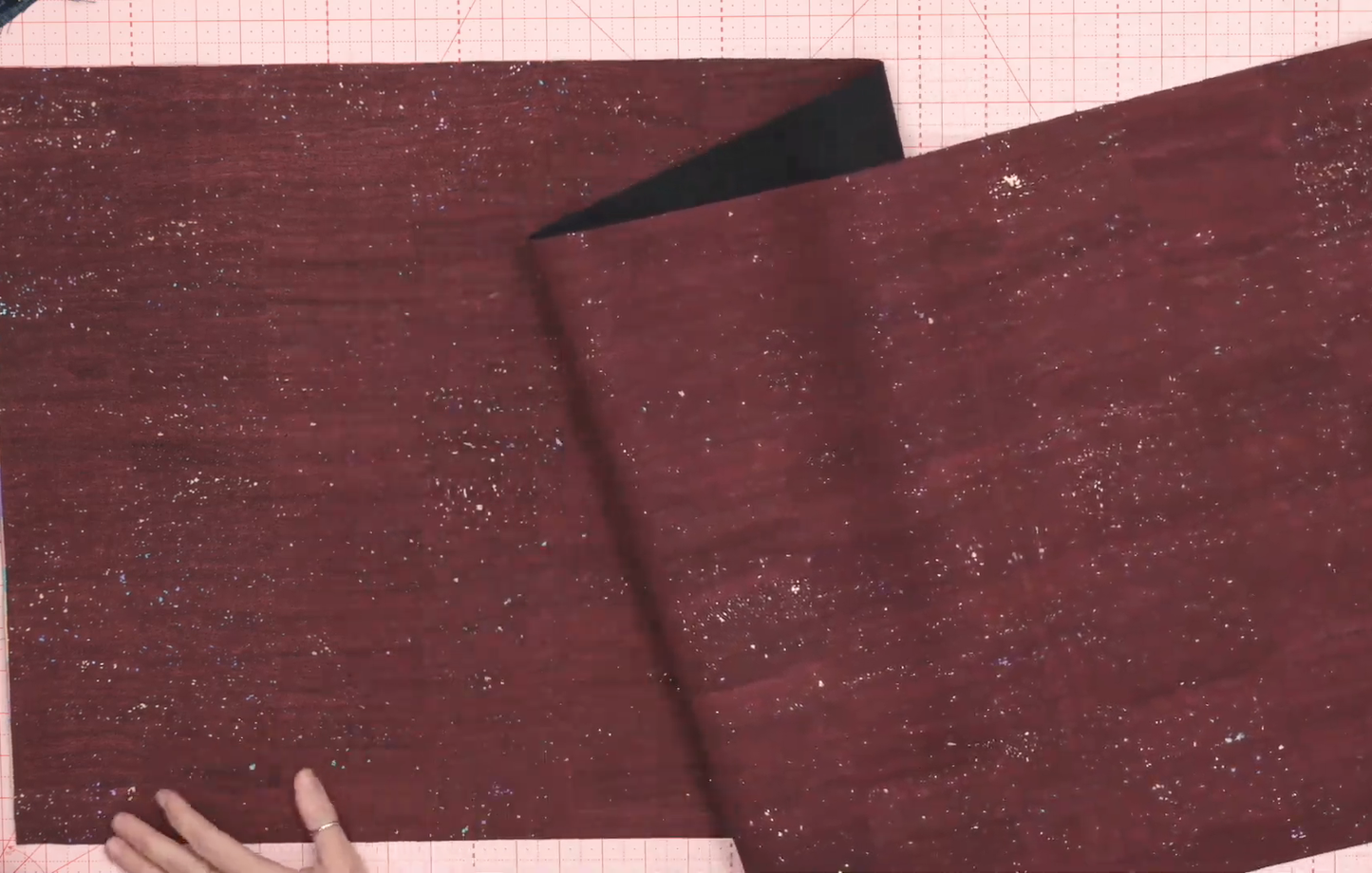Screenshot of dark red fabric on a pink cutting mat.