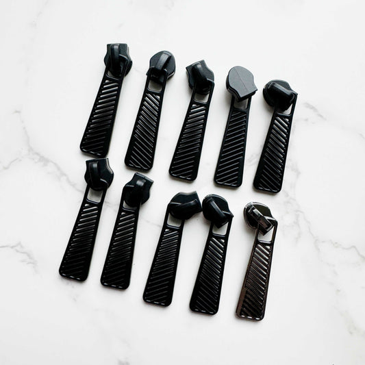 Ten black zipper pulls arranged in two rows of five.