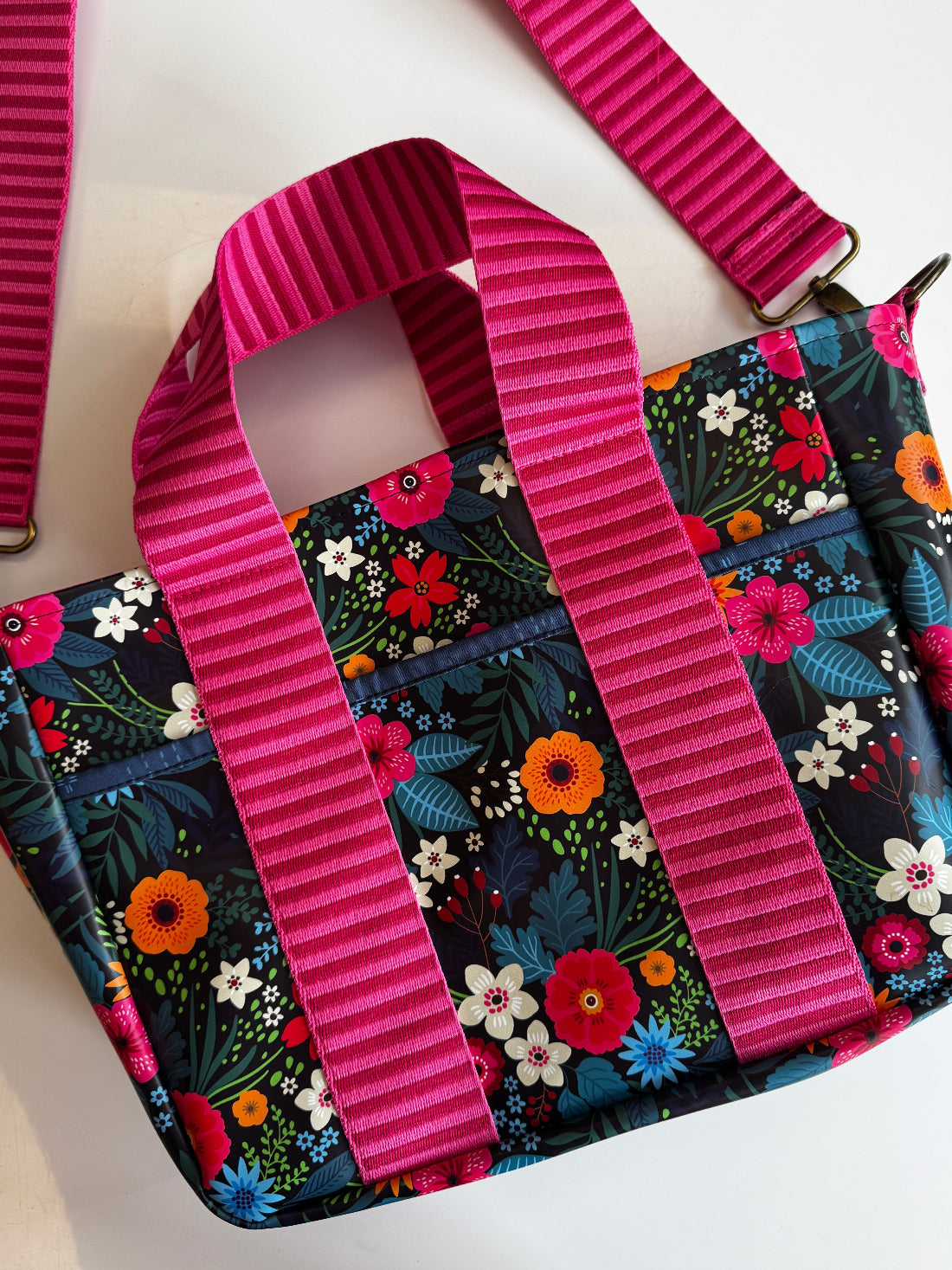 Floral-patterned bag with a pink strap on a white background