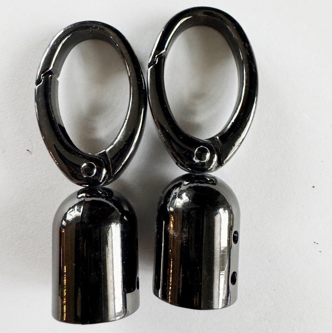 Pair of metallic tassel caps on a white background