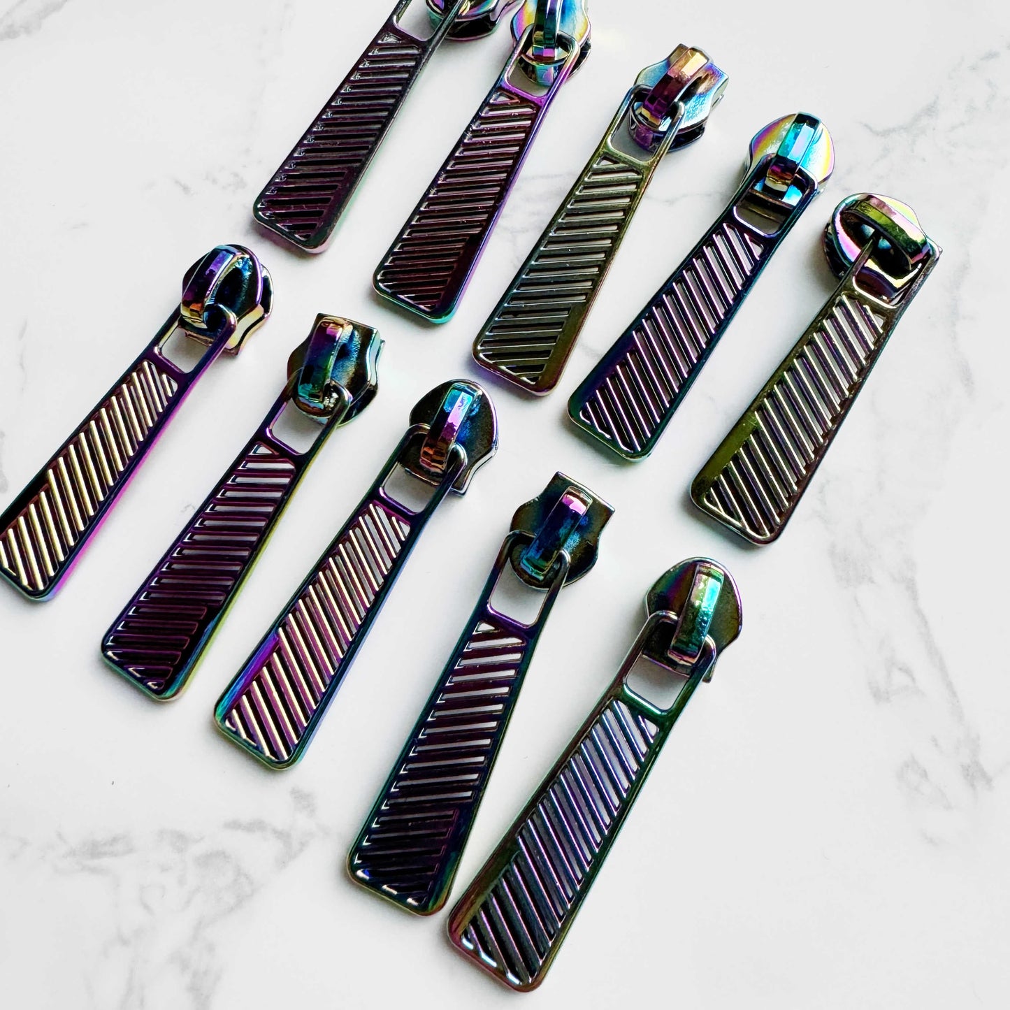 Ten rainbow zipper pulls arranged in two rows of five.