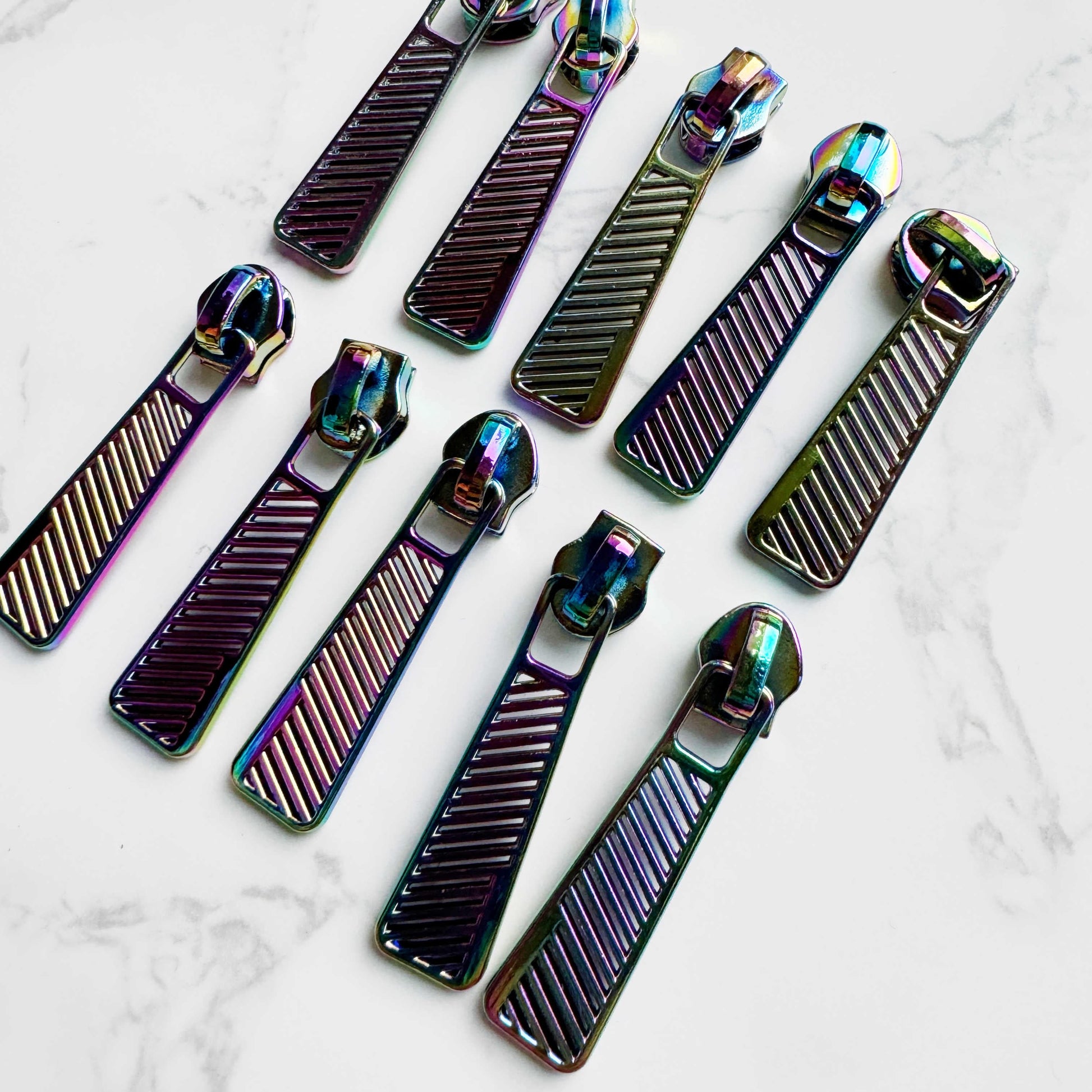 Ten rainbow zipper pulls arranged in two rows of five.
