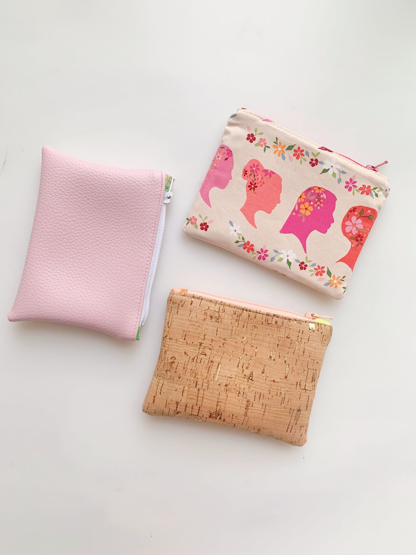 Three handmade coin purses in pink, floral, and cork