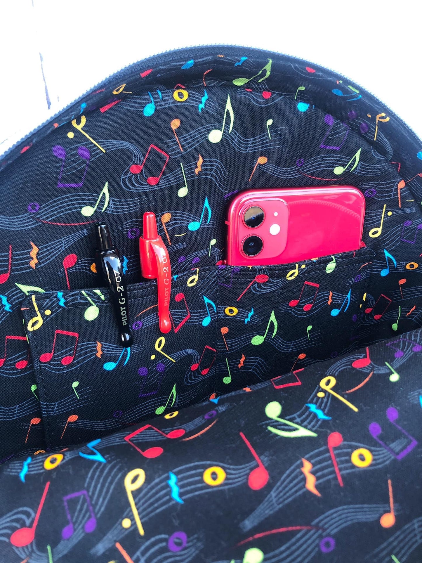 Inside musical-themed bag with phone and pens.