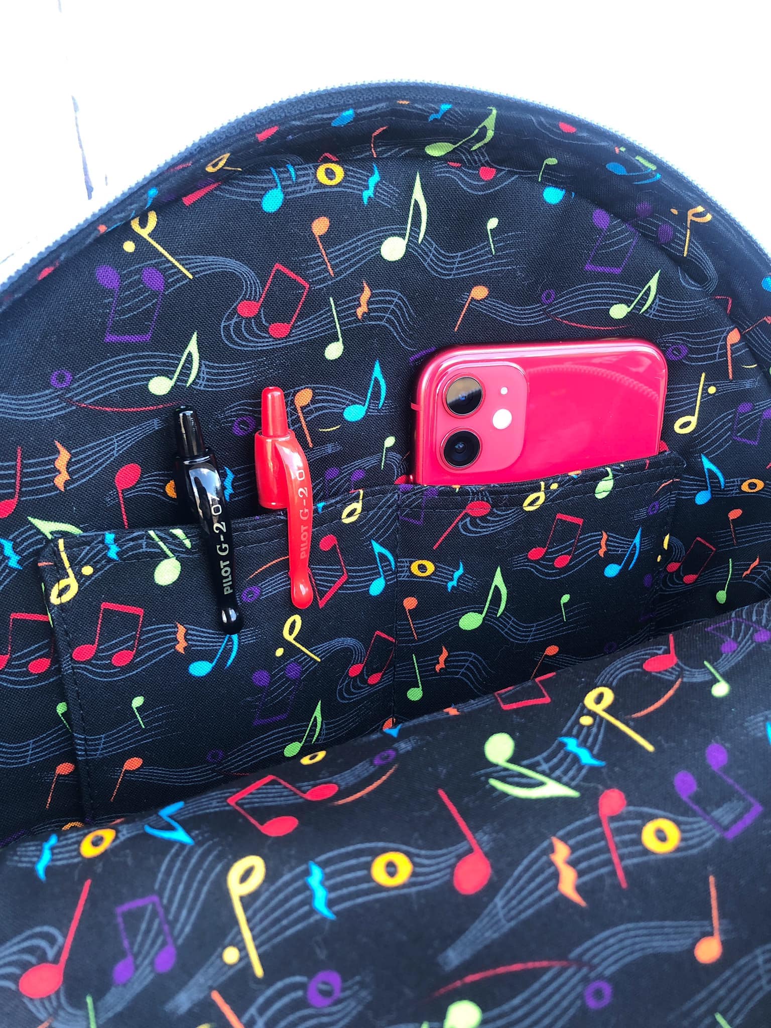 Inside musical-themed bag with phone and pens.