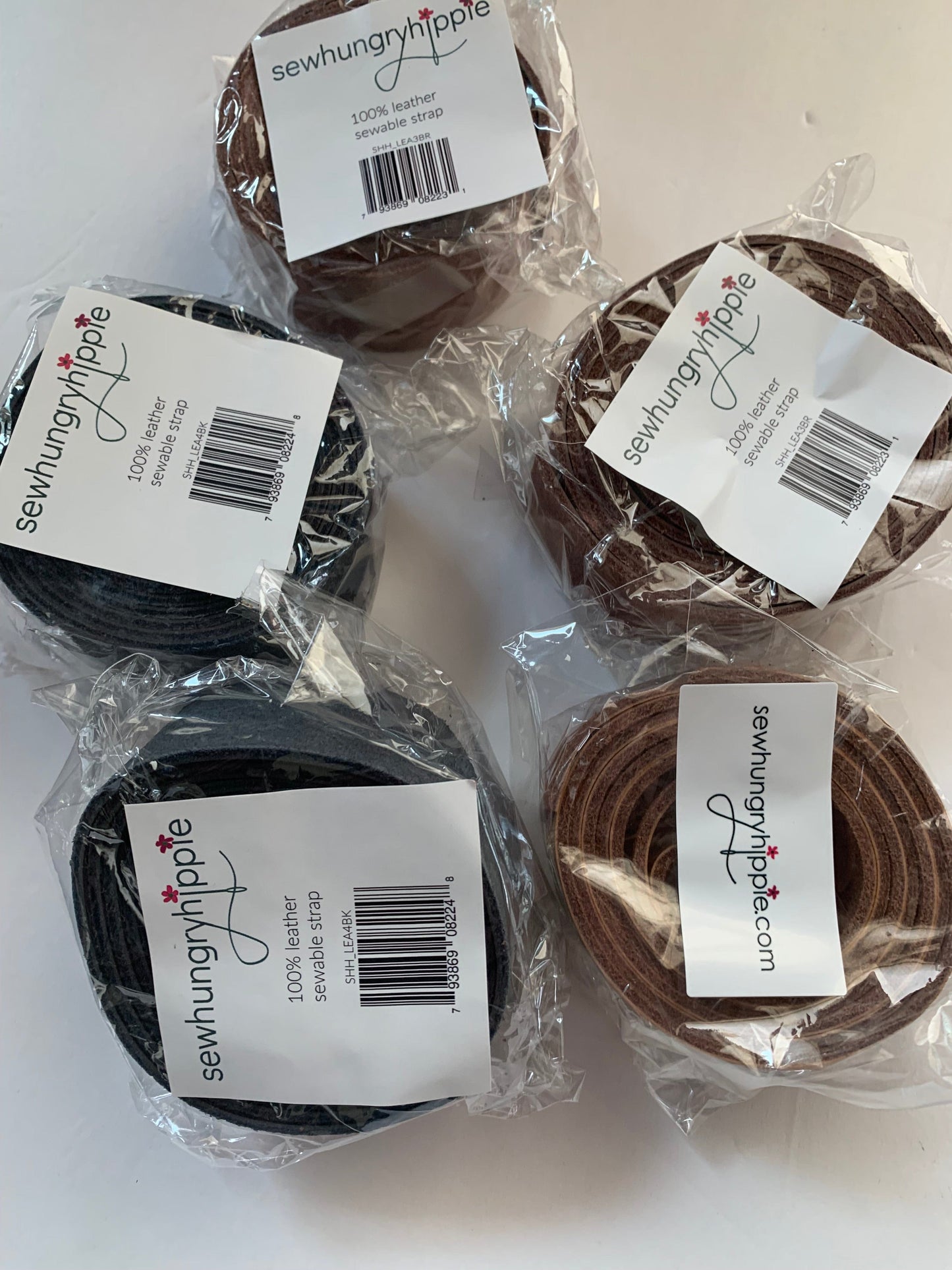Five spools of leather strip with labels.