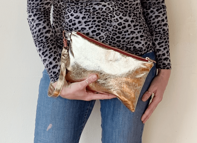 Woman holding a gold clutch.