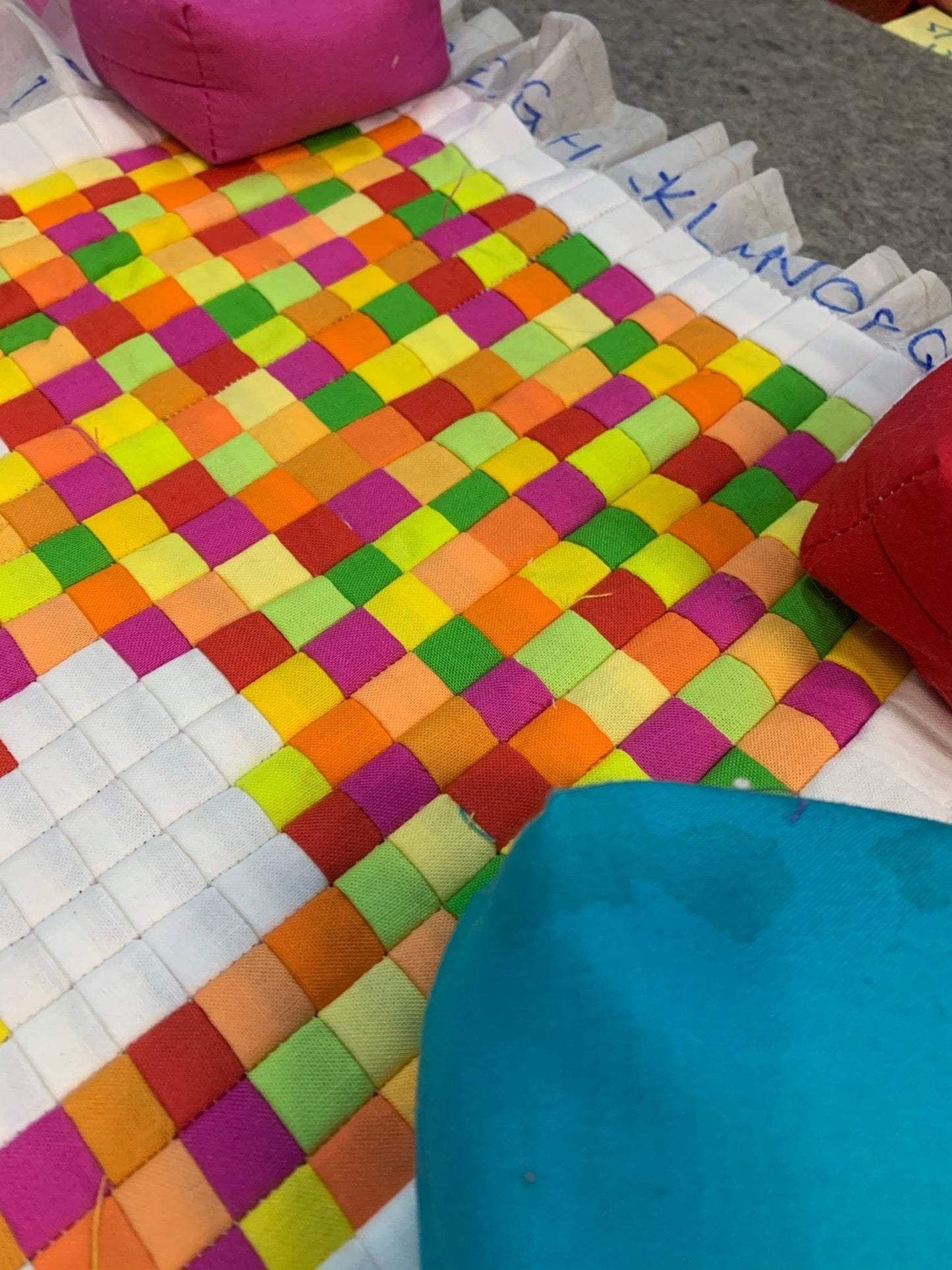 Colorful woven fabric squares with pillows.