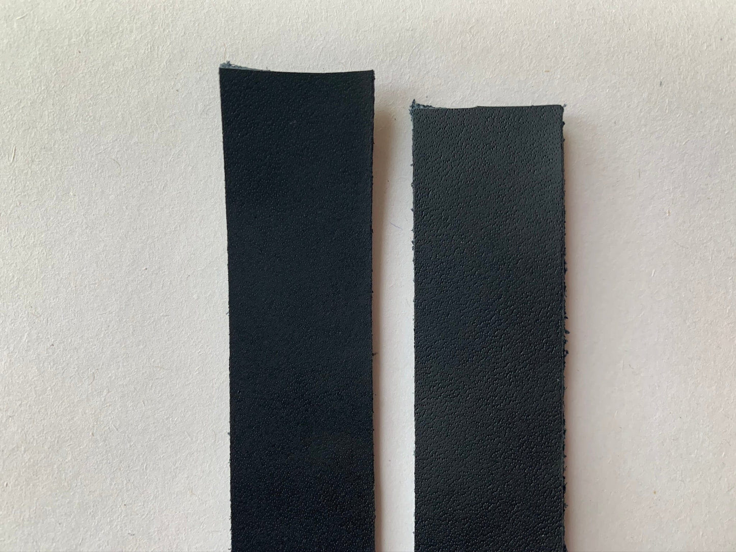 Two black rectangular leather strips.