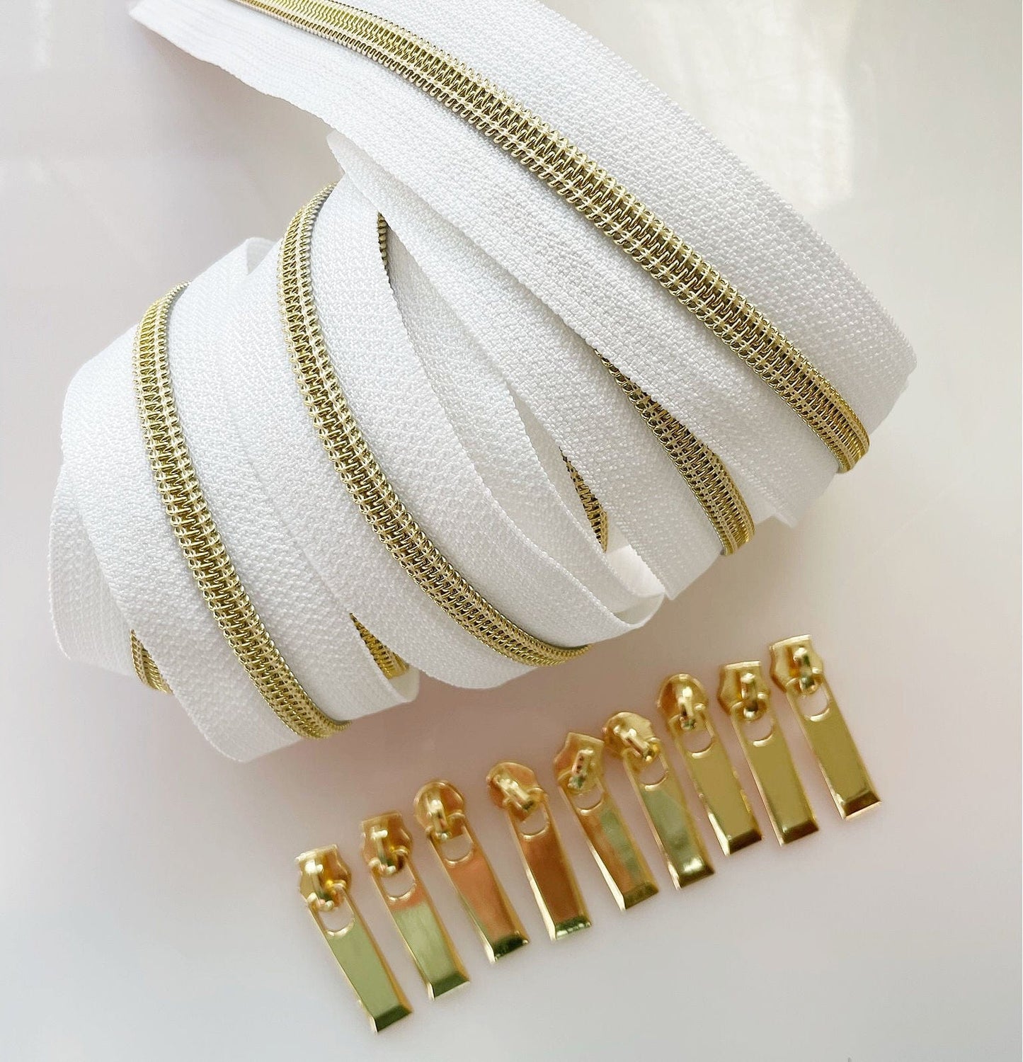 White zipper tape with gold teeth and pulls.
