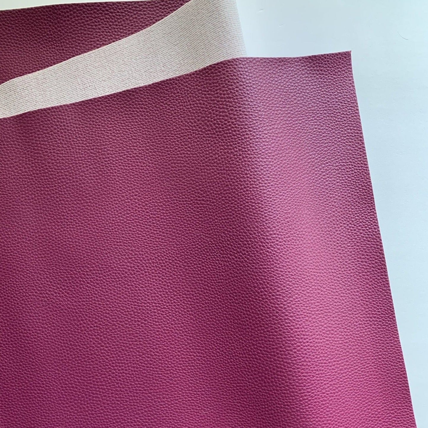 Burgundy textured fabric with a tan backing.
