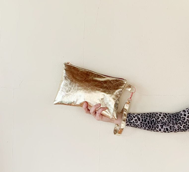 Gold clutch bag held in hand