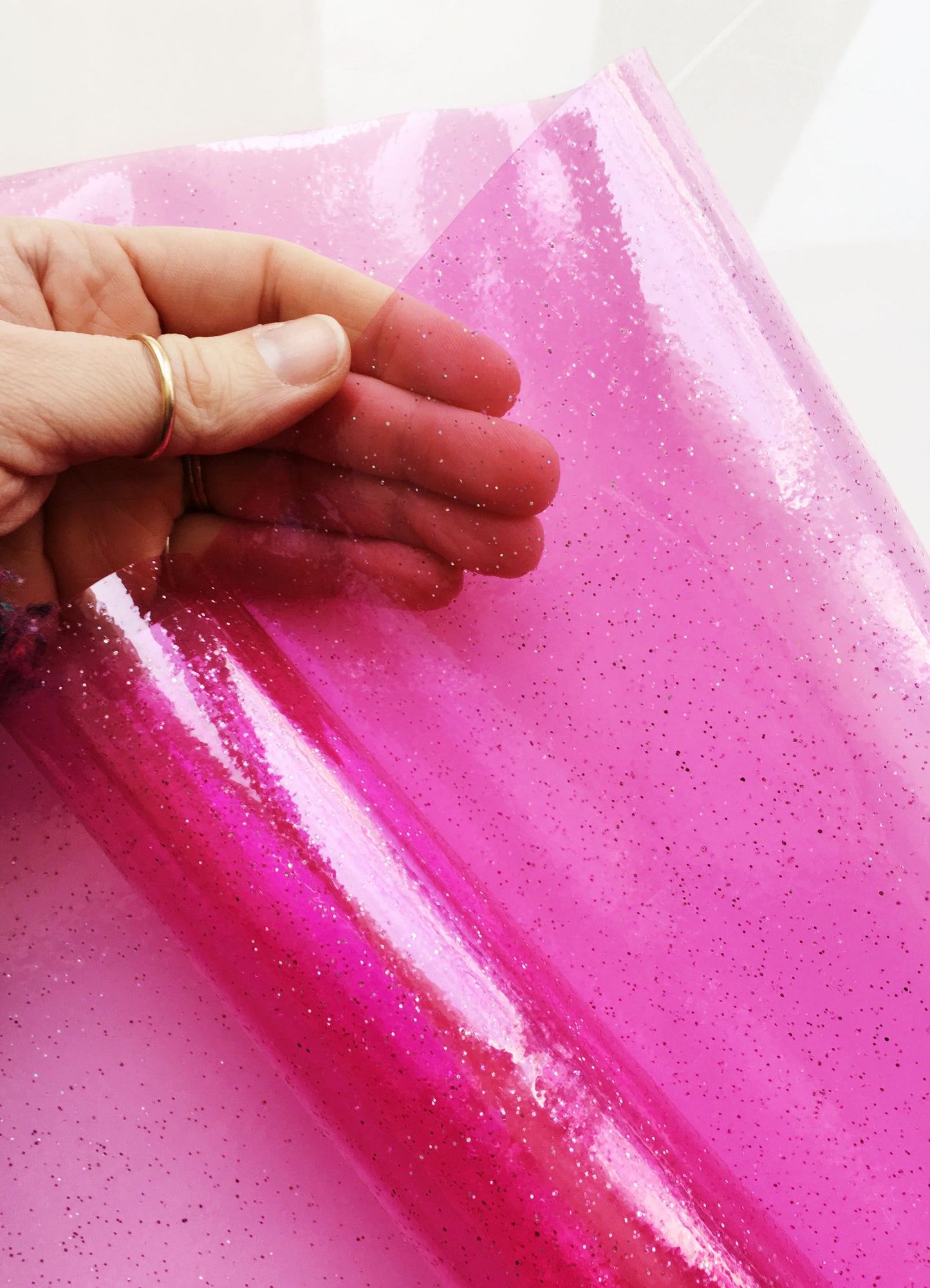 Hot pink glitter vinyl sheet held in hand