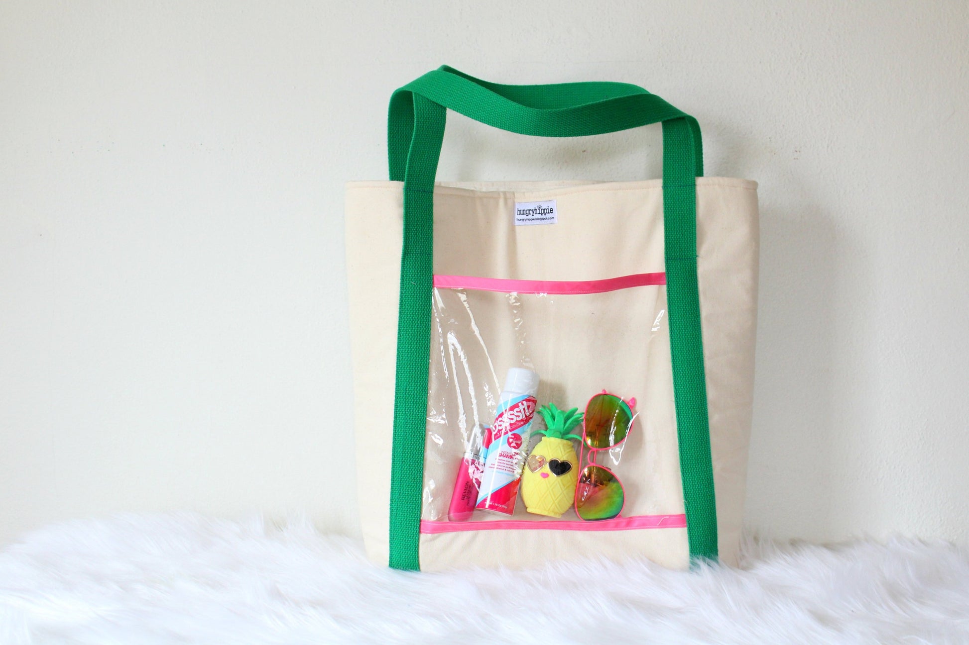 Green-handled tote bag with clear pocket and summer items