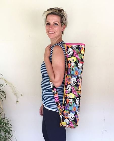 Woman with yoga mat bag featuring skulls