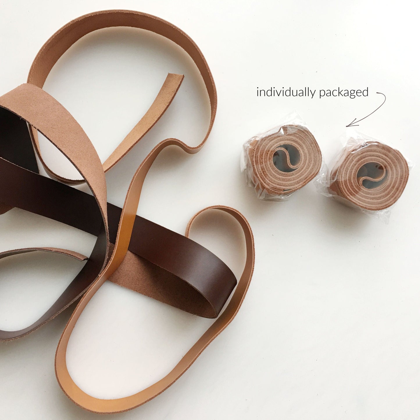 Leather straps, tan and brown, rolled and packaged
