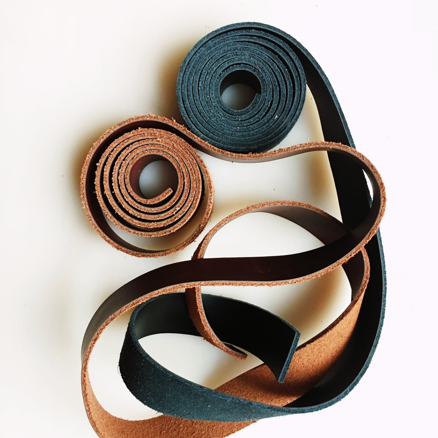 Leather straps in brown and navy blue rolls