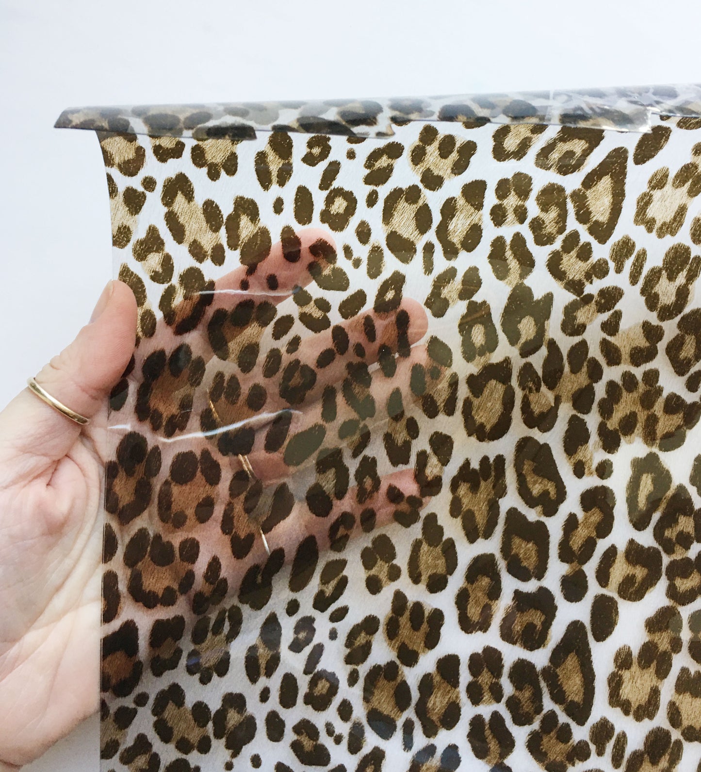 Hand holding leopard print vinyl sheet