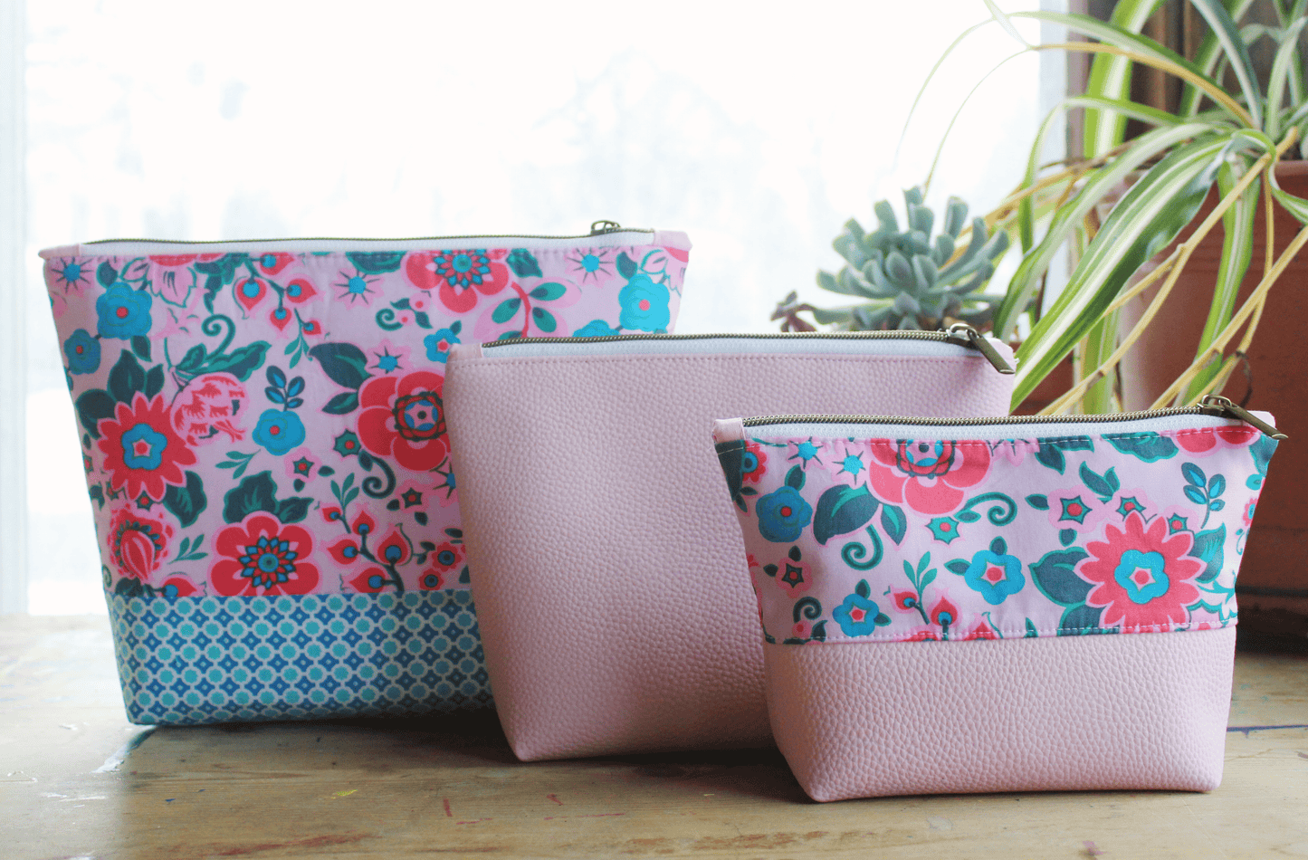 Longshot of three floral and pink cosmetic bags