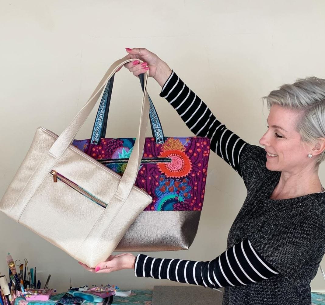 Woman holding moonglow vinyl champagne tote bags