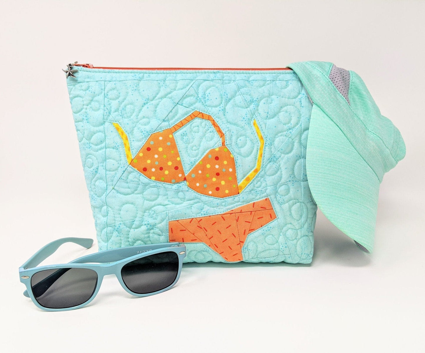 Pam's turquoise beach bag with bikini, sunglasses, and hat