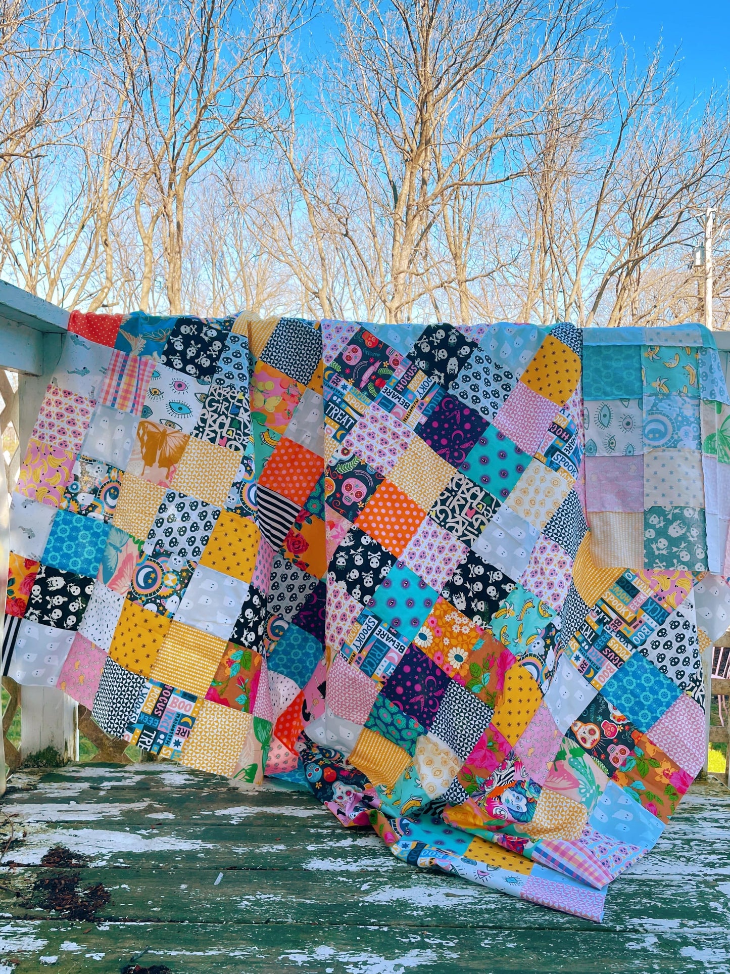 Patchwork quilt pattern with colorful squares hanging outdoors