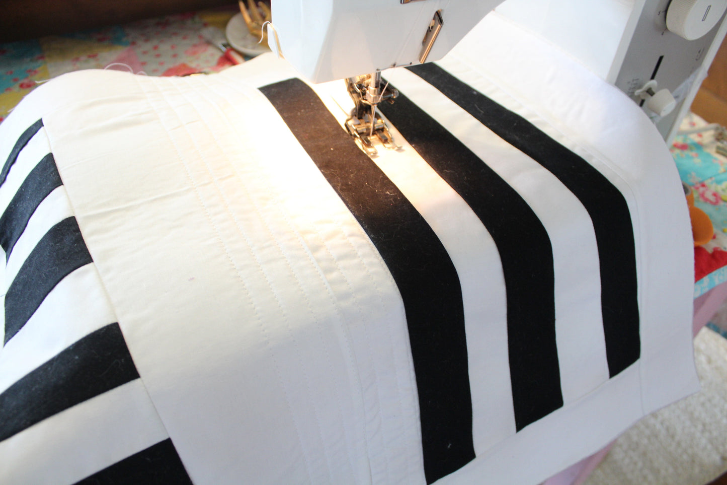Sewing machine stitching black and white striped fabric - photo 1 of 2