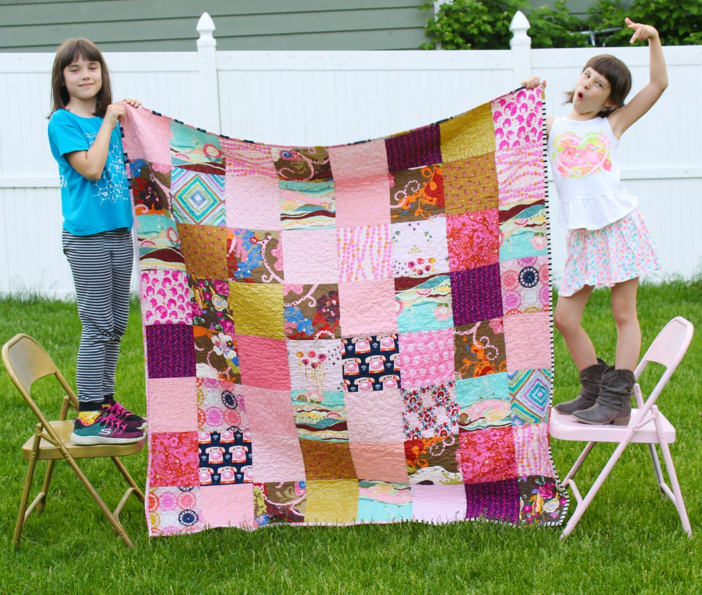 Girls holding a pink patchwork quilt