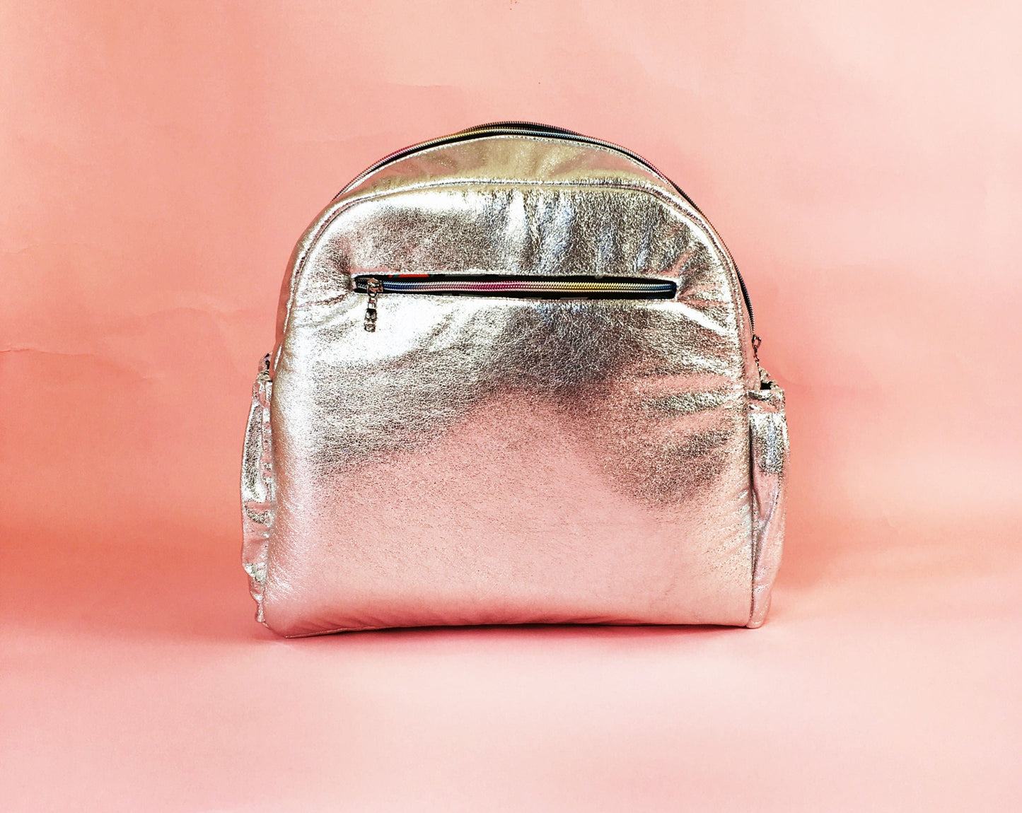 Silver backpack on pink background