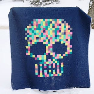 Pixelated skull quilt in snow