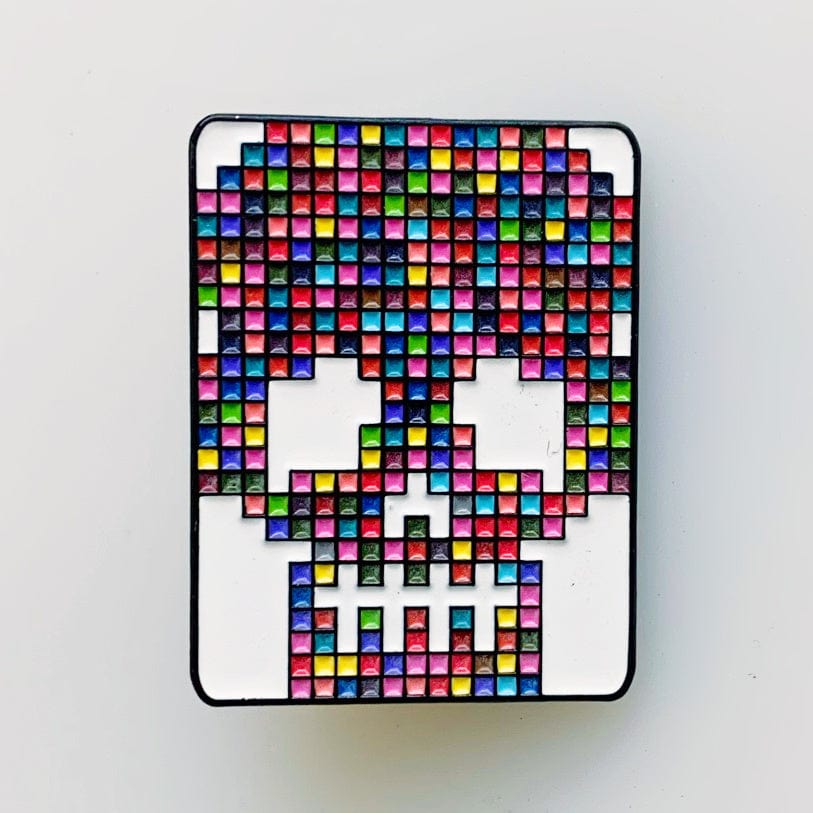 Skull pin closeup with colorful pixelated design.