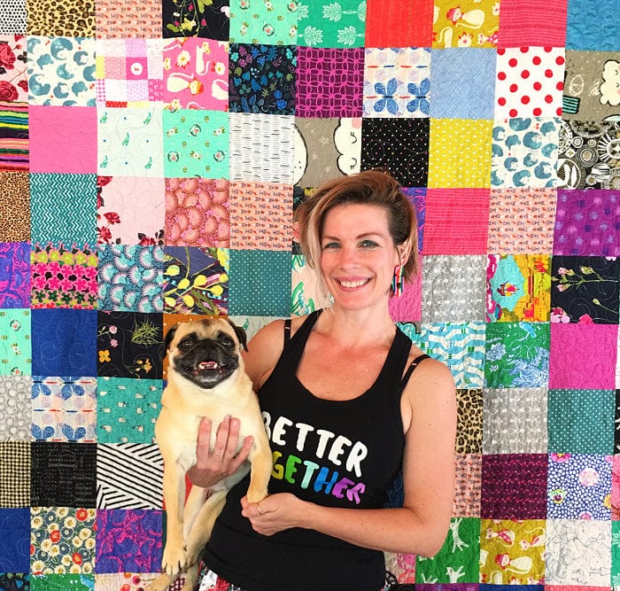 Woman & pug with colorful quilt backdrop.